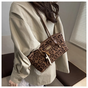 Detail of leopard print handbag featuring beaded tassel and vintage shoulder strap style