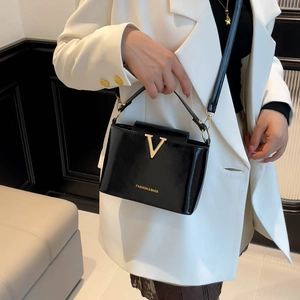 Glossy black leather shoulder bag with golden V logo and fashion inscription for women