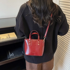 Chic red mini bucket bag in glossy finish with gold lettering and detachable strap