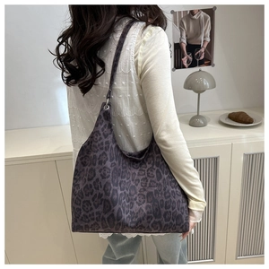 Detailed side view of large leopard print tote bag with metallic silver ring attachment