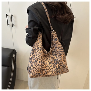 Detail of a large leopard print tote bag with a soft drape on a model side view
