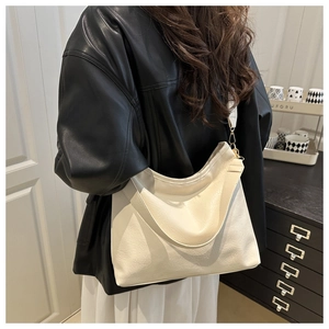 Détail du sac hobo crème avec texture en cuir souple et crochet en métal doré