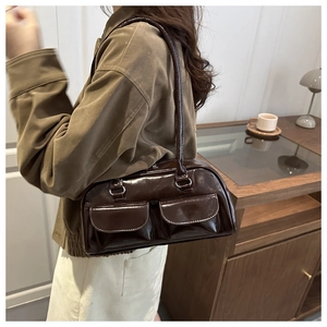Detail of dark brown glossy leather Boston bag with functional double front flap pockets