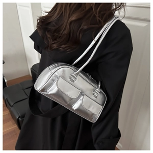 Detail of silver metallic Boston bag with two front pockets on a model's black coat