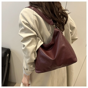 Détail du sac hobo bordeaux montrant la texture du cuir souple et la boucle dorée