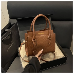 Detail of brown crocodile pattern small square bag showing fine embossed leather texture