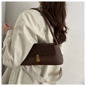Détail du sac baguette rétro marron foncé avec rabat léopard et boucle en métal doré