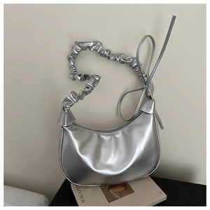 Detail of silver metallic hobo bag featuring knotted ruched straps and moon shape design