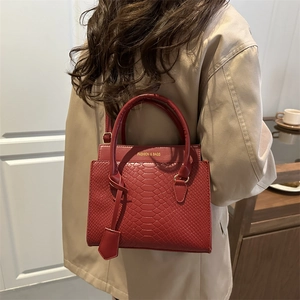 Chic dark red snake-pattern crossbody bag for women styled with a classic trench coat