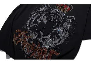 Détail des strass brillants formant une tête de tigre et couronne sur T-shirt noir