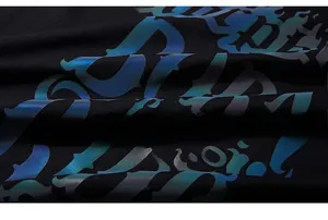 Detail of a black T-shirt featuring rainbow reflective Gothic letter printing on the fabric