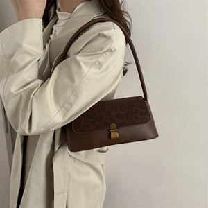 Brown underarm bag with leopard print flap and gold buckle worn with a beige trench coat