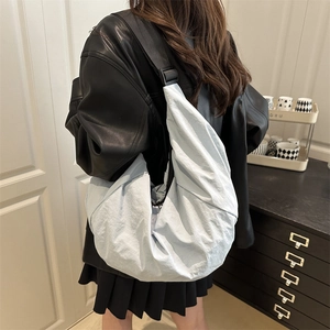 Stylish light blue oversized crescent crossbody bag with adjustable black shoulder strap