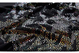 Vue macro de strass colorés et gemmes étincelantes sur le tissu noir d'un T-shirt