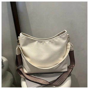 Détail du sac cabas crème avec texture litchi et bandoulière géométrique en tissu
