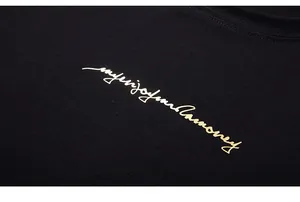 Macro shot of high-quality black cotton T-shirt featuring gold artistic lettering design