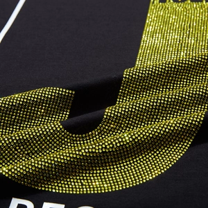 Gros plan d'un t-shirt noir oversize avec strass dorés et imprimé RE blanc pur