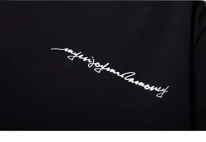 Gros plan détaillé sur l'impression calligraphique blanche du t-shirt en coton noir épais
