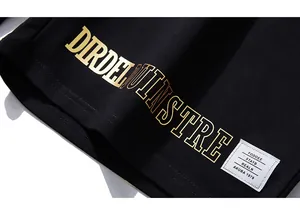 Détail du tissu en coton noir avec impression dorée et étiquette de marque cousue