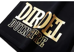 Détail du lettrage doré métallisé sur le short en coton noir de style streetwear