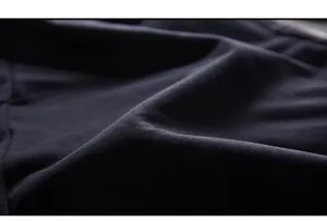Macro shot of high-density black knit fabric showing soft texture and premium cotton weave