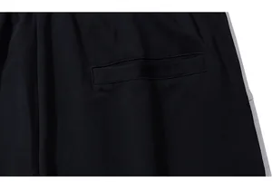 Dettaglio di una tasca posteriore a filo su pantaloncini sportivi neri in cotone
