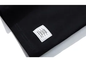 Detail of a black fabric hem featuring a white woven label with clean stitched edges