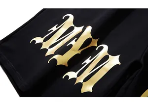 Detailed view of the gold metallic Gothic MM print on premium black cotton fabric
