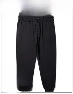Detail showing elastic drawstring waistband and deep side pockets on black joggers