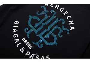 Macro shot of blue rhinestone emblem and text on black cotton oversized t-shirt fabric
