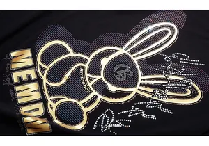 Close-up of rabbit print with gold foil and colorful rhinestones on black cotton T-shirt