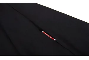 Close-up of black knit fabric side seam with red Fashion label and fine texture