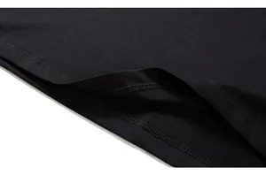 Detailed close-up of double-needle stitching and hem finish on a black cotton T-shirt