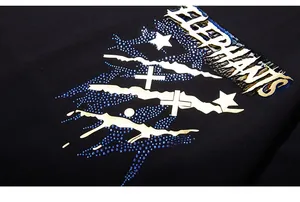 Détail du t-shirt avec imprimé doré ELEPHANTS et décorations en strass bleus brillants