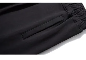 Macro shot showing high-quality knit texture and elastic waist of black joggers