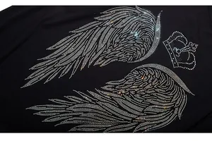 Close-up of sparkling rhinestone feather wings and crown design on black t-shirt