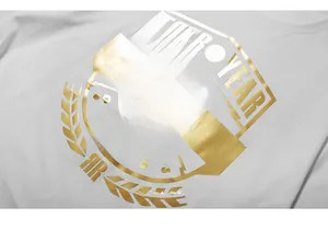 Dettaglio del logo in lamina d'oro sul tessuto di una t-shirt in cotone bianco premium