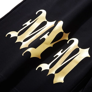 Men's loose knit shorts with large metallic gold Gothic MM print detail on black fabric