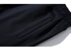 Detail of elastic waistband and side pocket on black knit sports shorts with precise stitching