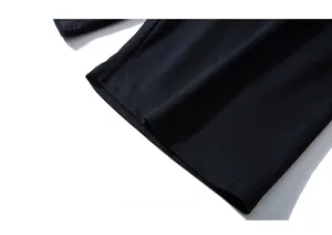 Detail shot of double-needle flat-lock stitching on black knitted sports shorts hem
