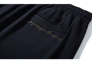 Détail du short de sport noir avec taille élastique et lettrage en strass dorés brillants