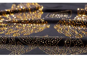 Macro detail of golden rhinestones on black T-shirt with premium bokeh lighting effect