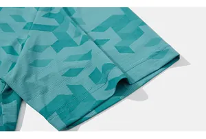 Détail de la manche d'un t-shirt de sport turquoise avec mesh respirant et motif géométrique