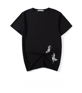 Detail der weißen Kranich-Stickerei auf einem schwarzen Baumwoll-T-Shirt mit Stickerei