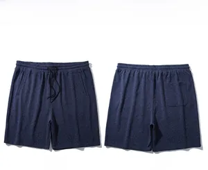 Detailed view of elastic waistband with black drawstring on textured navy sports shorts