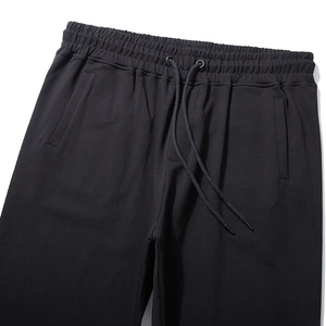 Men's minimalist black jogger pants featuring an elastic drawstring waist and side pockets