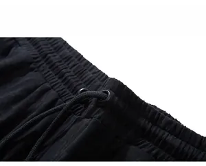 Detail of black sports shorts featuring elastic waistband with woven drawstrings