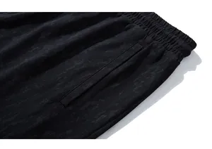 Detail of elastic drawstring waistband and side pocket on men's marbled sports shorts