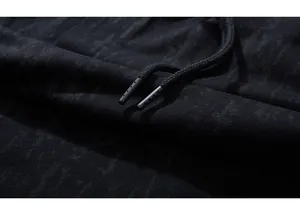 Macro detail of acid-washed black cotton fabric with dual woven drawstrings on shorts
