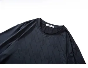 Detail of moisture-wicking fabric with geometric pattern and 3XL size label on collar